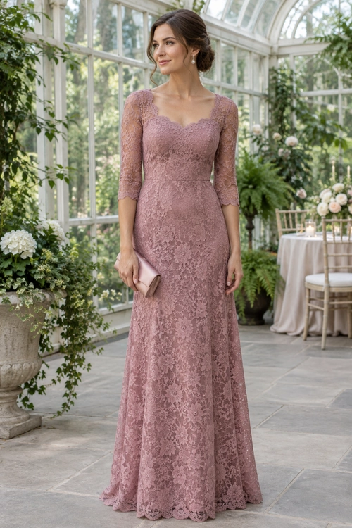 A woman wears a floor-length dusty rose lace gown with three-quarter sleeves, drop earrings, and a small blush clutch.